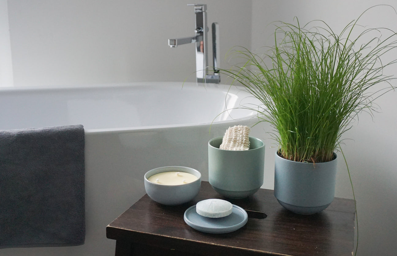Badewanne mit Keramikgefäßen für Seife, Kerze und Waschlappen